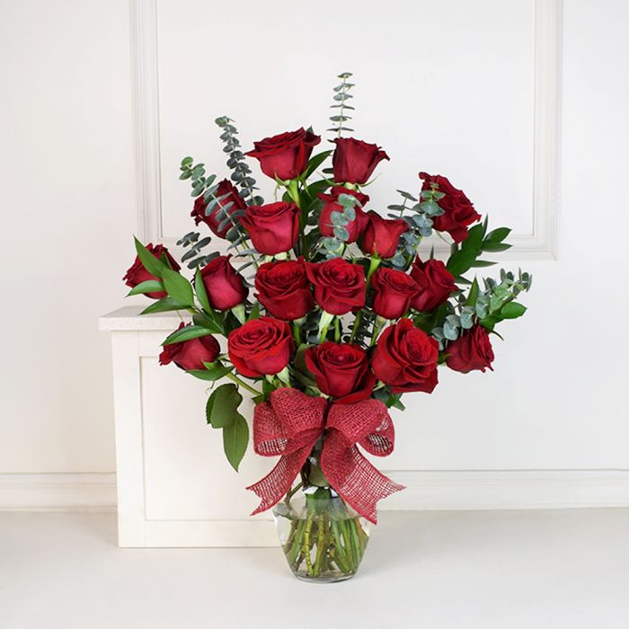 Arreglo de jarrón con rosa roja y eucalipto.