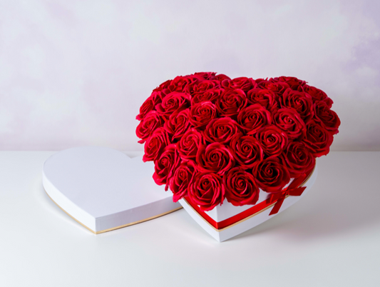 Rosas frescas en una caja en forma de corazón.